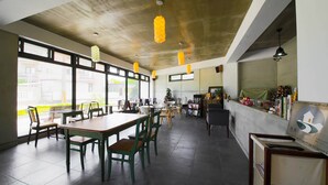 A spacious restaurant with high ceilings, large windows, and modern pendant lighting. - Dong Pan B&B (Shoufeng)