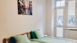 Une chambre à coucher avec un lit, une fenêtre et un tableau accroché au mur.