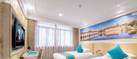 Habitación de hotel con dos camas, un escritorio, un televisor y un ventanal grande.