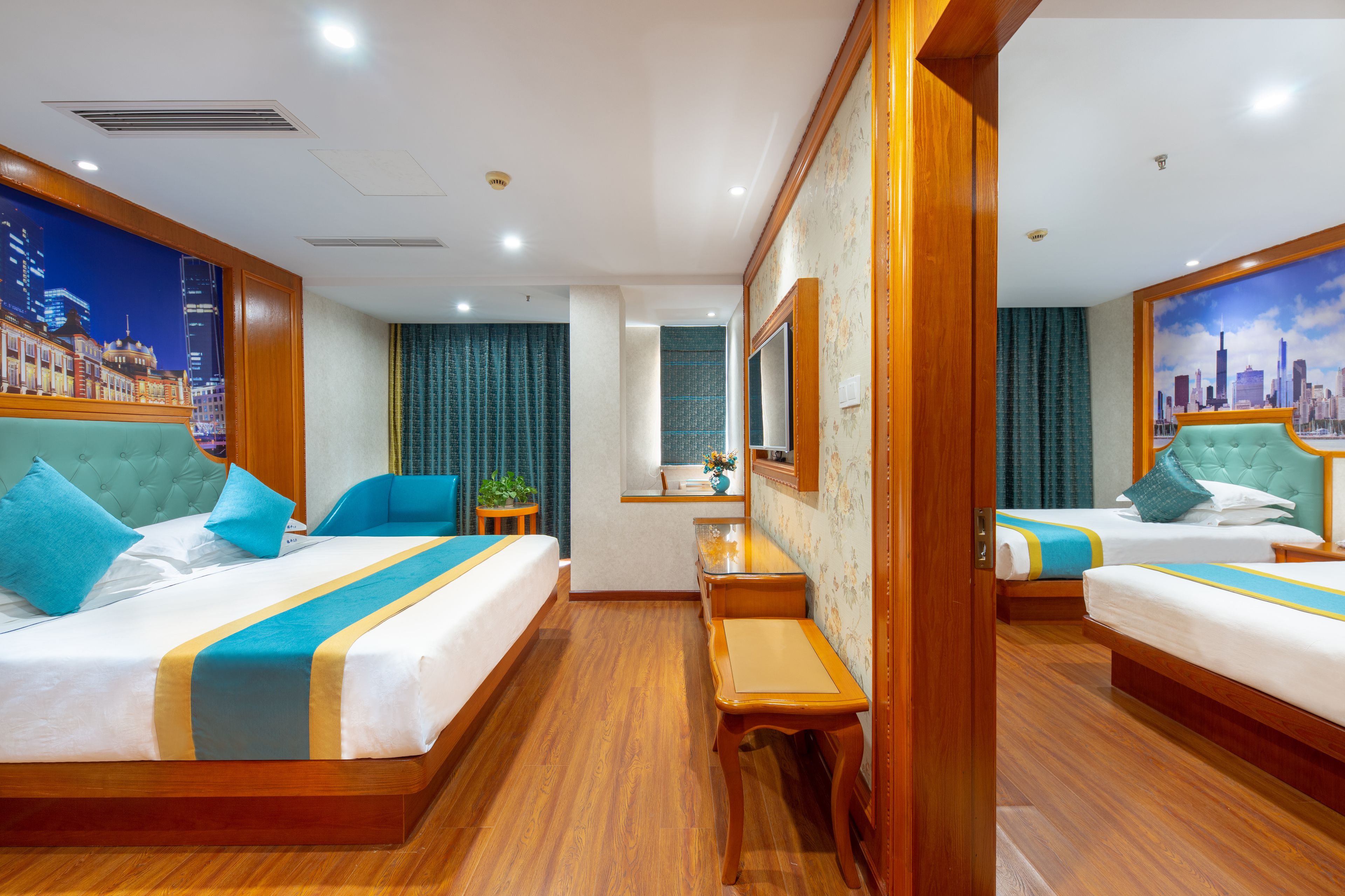 A hotel room with two beds, a small desk, a mirror, and a cityscape view.