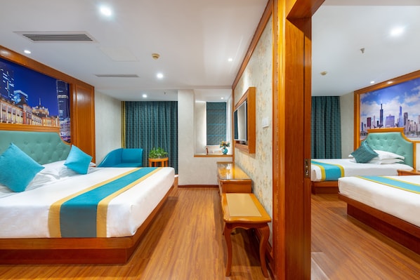 Habitación de hotel con dos camas, un escritorio pequeño, un espejo y vistas a la ciudad.
