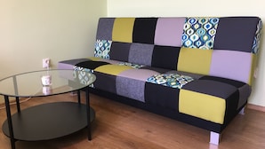Un salon moderne avec un canapé, une table basse en verre et une prise de courant.
