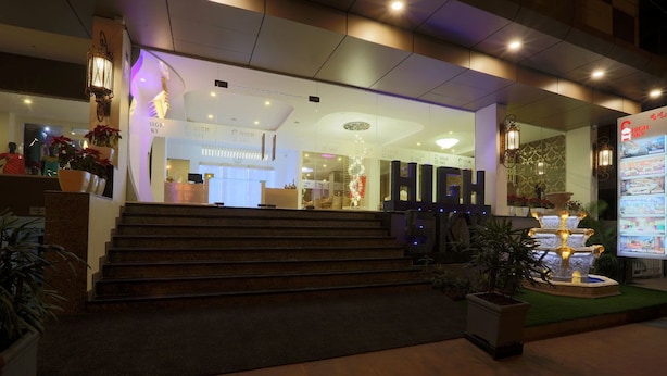 A hotel entrance with a staircase leading up to the reception area.