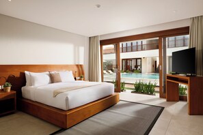 Habitación de hotel moderna con una cama grande, televisor y vistas a una piscina.