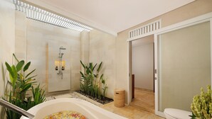 Une salle de bain moderne avec une baignoire remplie de fleurs, un espace douche et des toilettes.