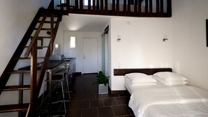 A bedroom with a bed, a desk, and a staircase. - Hôtel Mas le Sauvageon (Saintes-Maries-de-la-Mer)