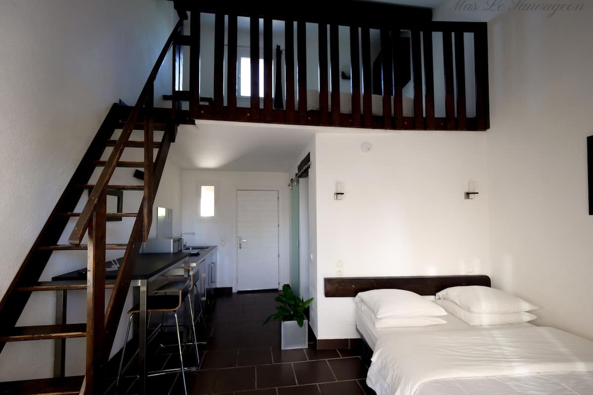 Une chambre à coucher avec un lit, un bureau et un escalier.