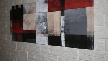 A large abstract painting on a white brick wall.