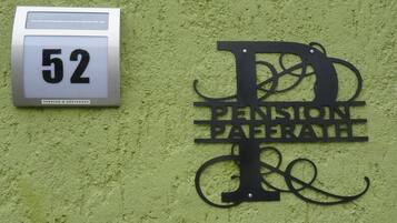 Un letrero de edificio con el número 52 y una placa metálica decorativa que dice "PENSION PAFFERT".