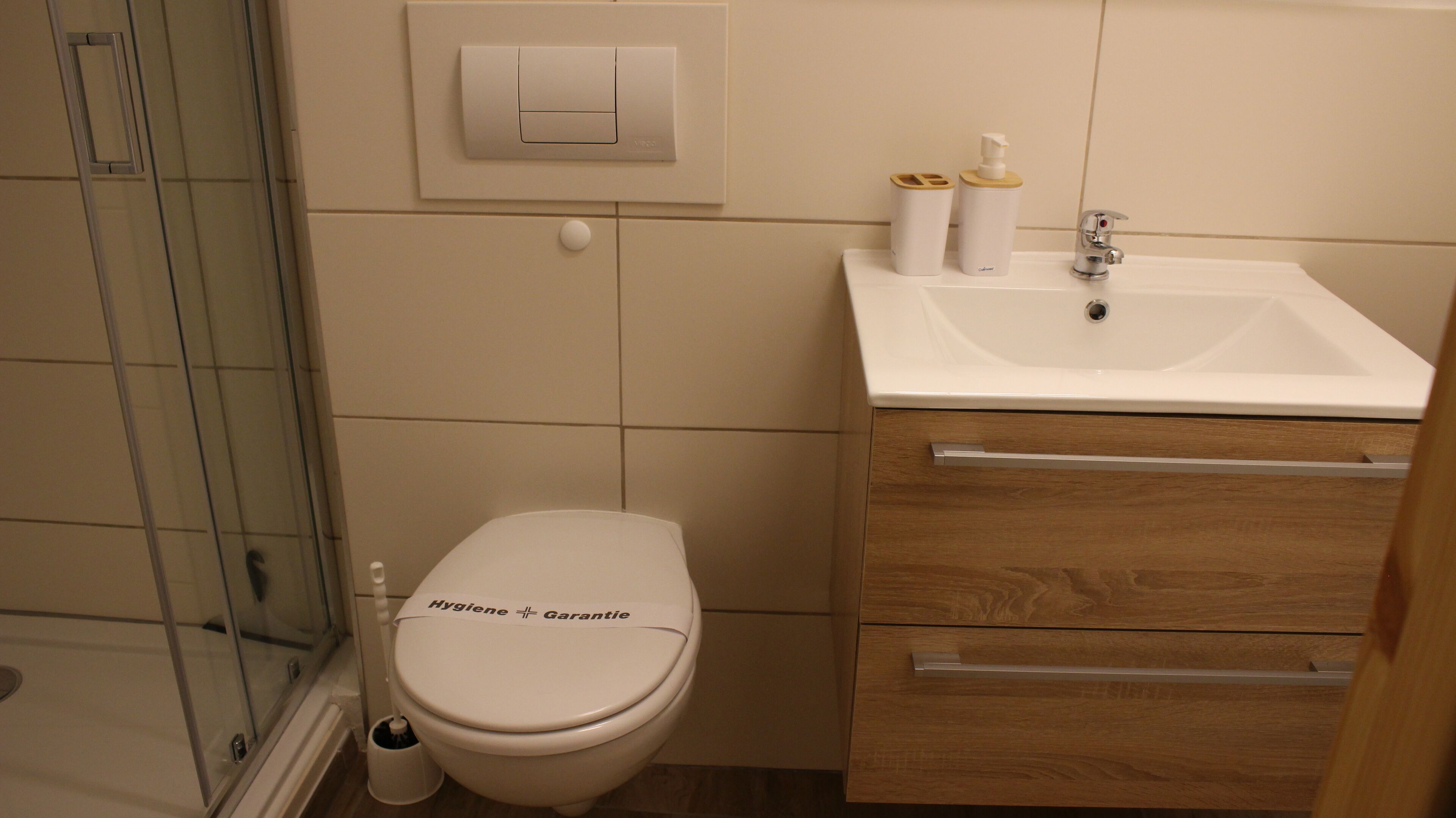 A bathroom with a toilet, a sink, and a shower.