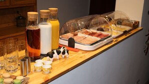 Ein reichhaltiges Frühstücksbuffet mit Speisen, Getränken und einer dekorativen Kuhfigur.