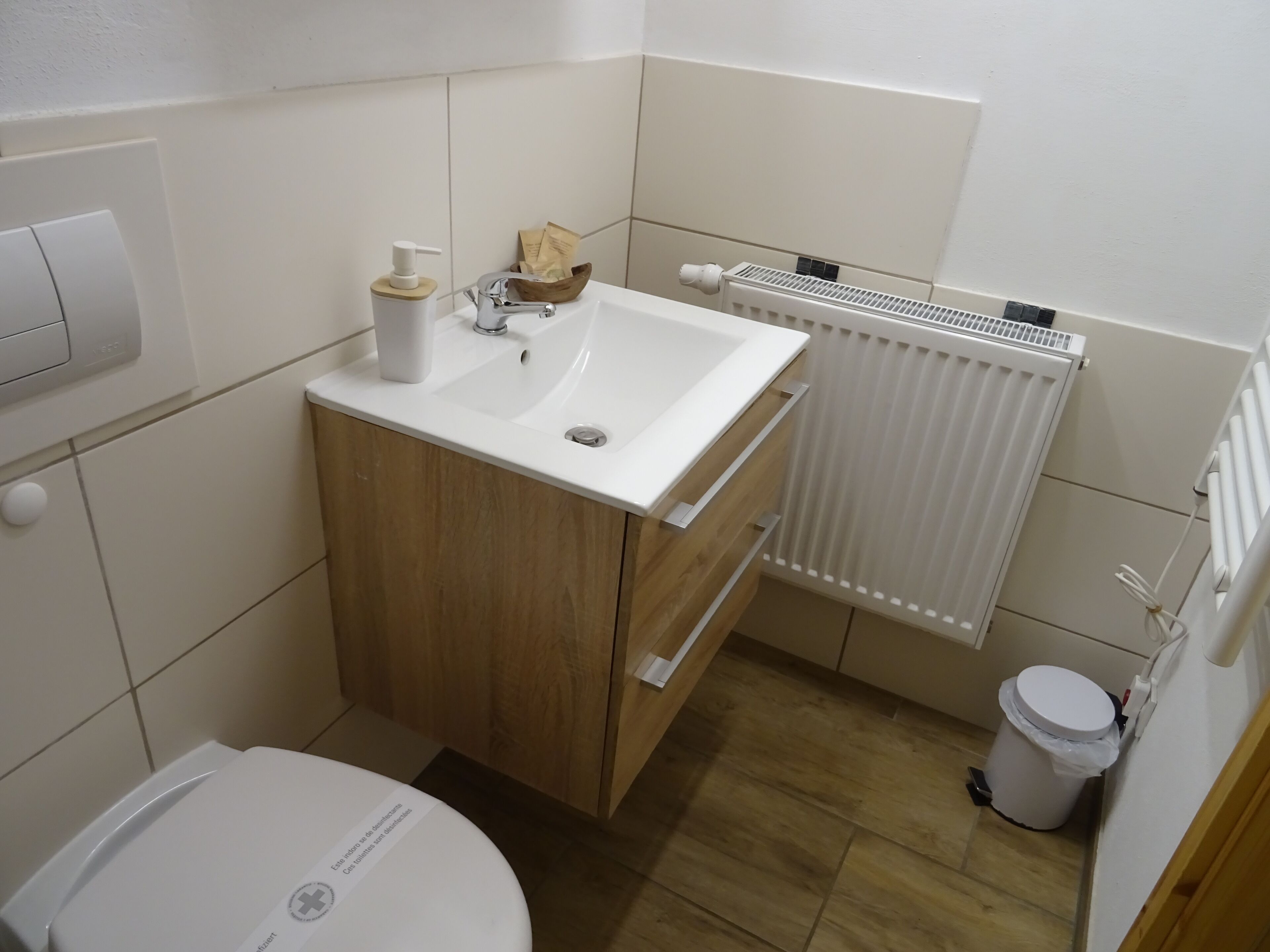 A small bathroom with a toilet, sink, and radiator.