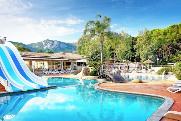 Een seizoensgebonden buitenzwembad en ligstoelen