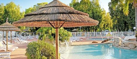 Una piscina al aire libre de temporada, sillones reclinables de piscina