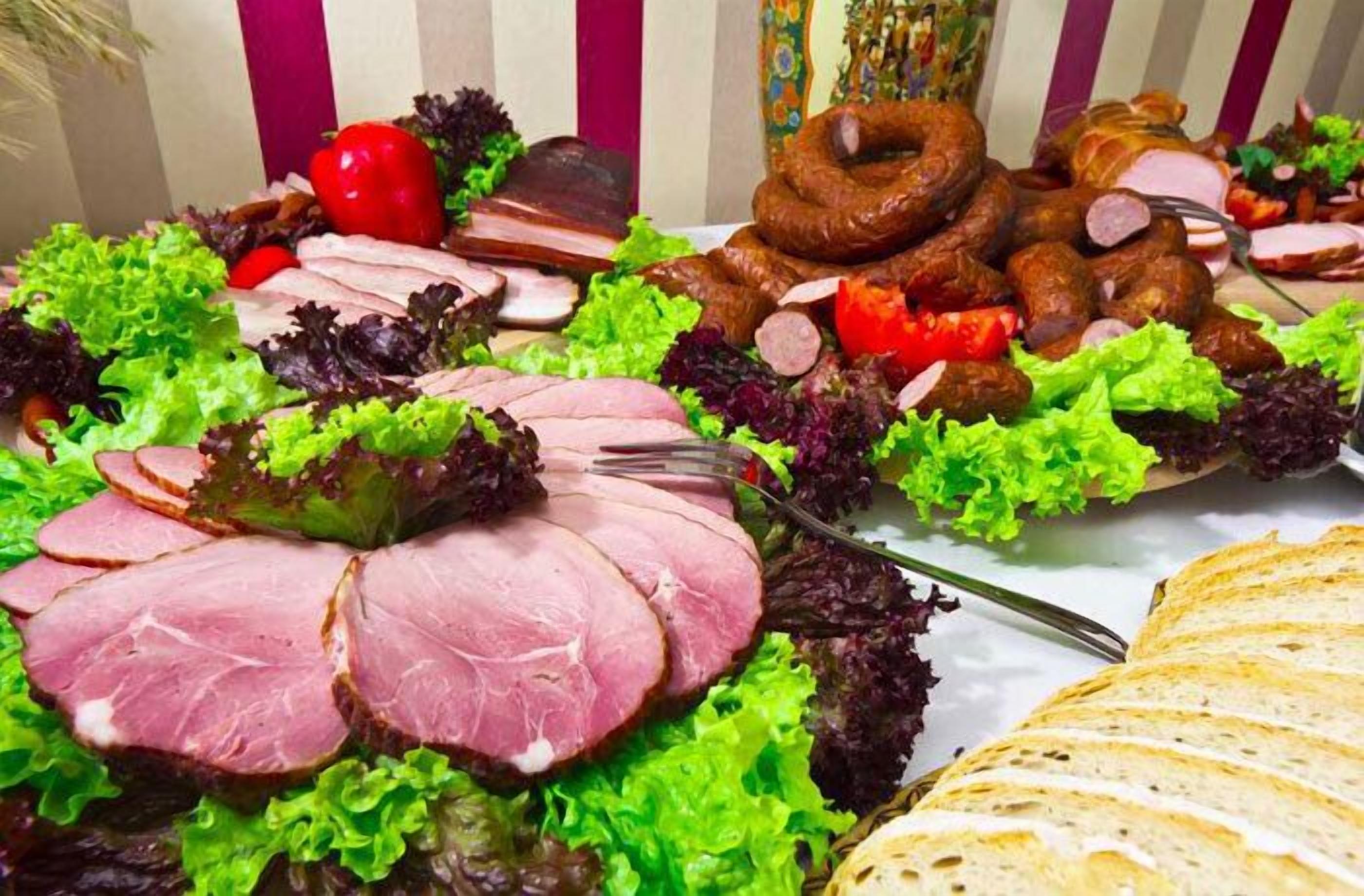 Un buffet proposant une variété de viandes, de saucisses et de légumes frais.
