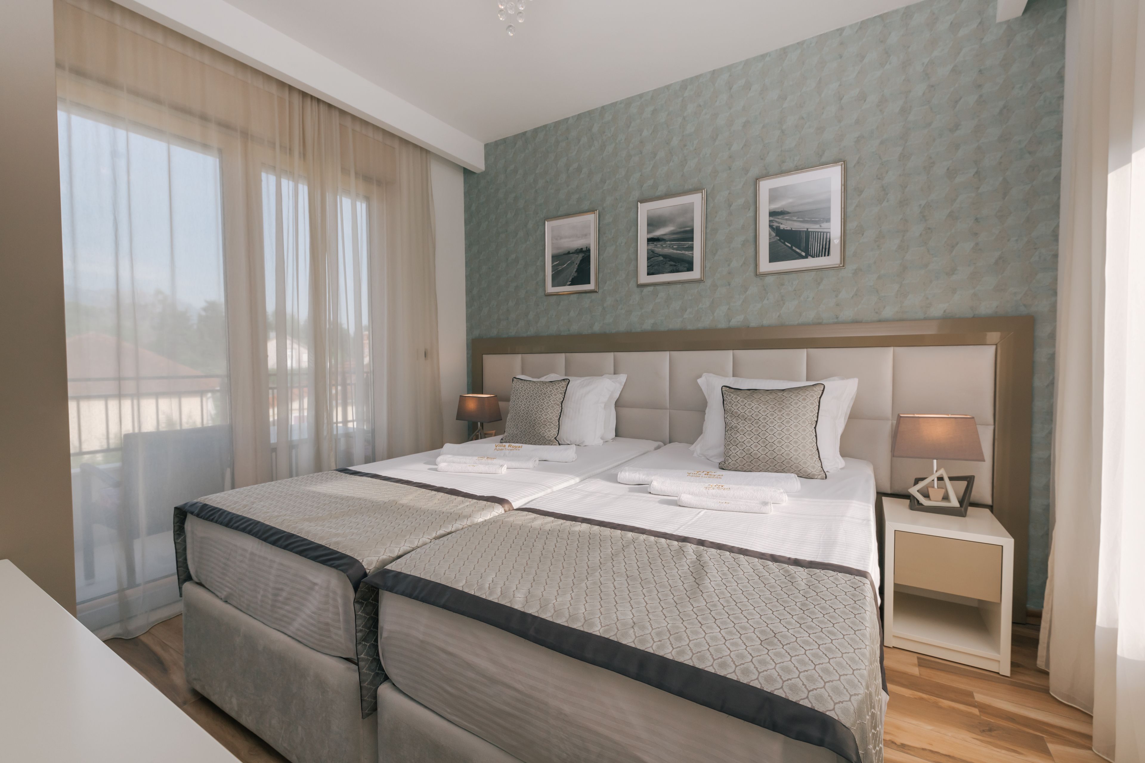 A double bed with a headboard, two bedside tables, and a window with curtains.