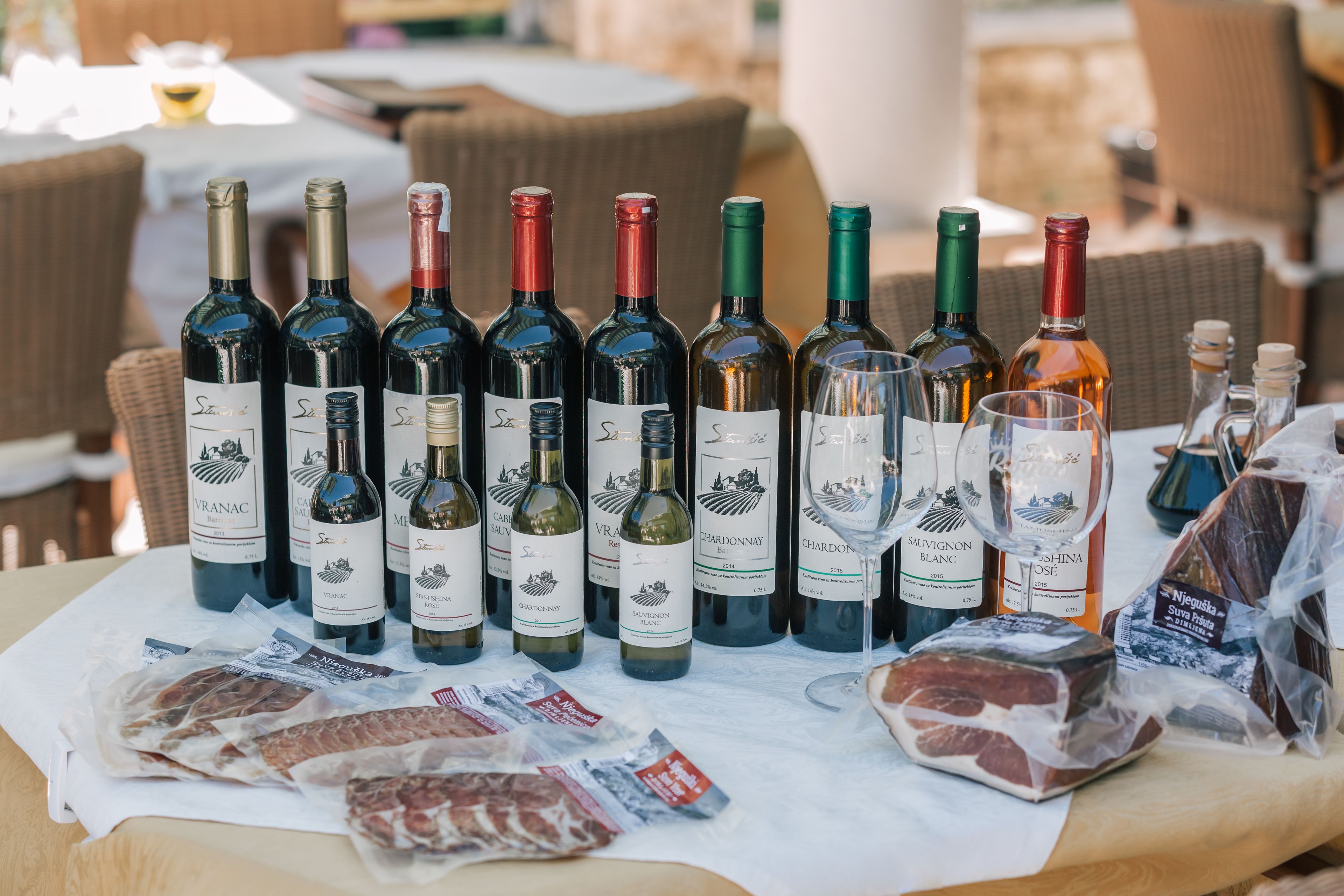 Una mesa con varias botellas de vino y paquetes de carne.