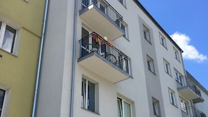 A multi-story residential building with balconies, windows, and a visible door. - Visit Lublin Apartments Piłsudskiego (Lublin)