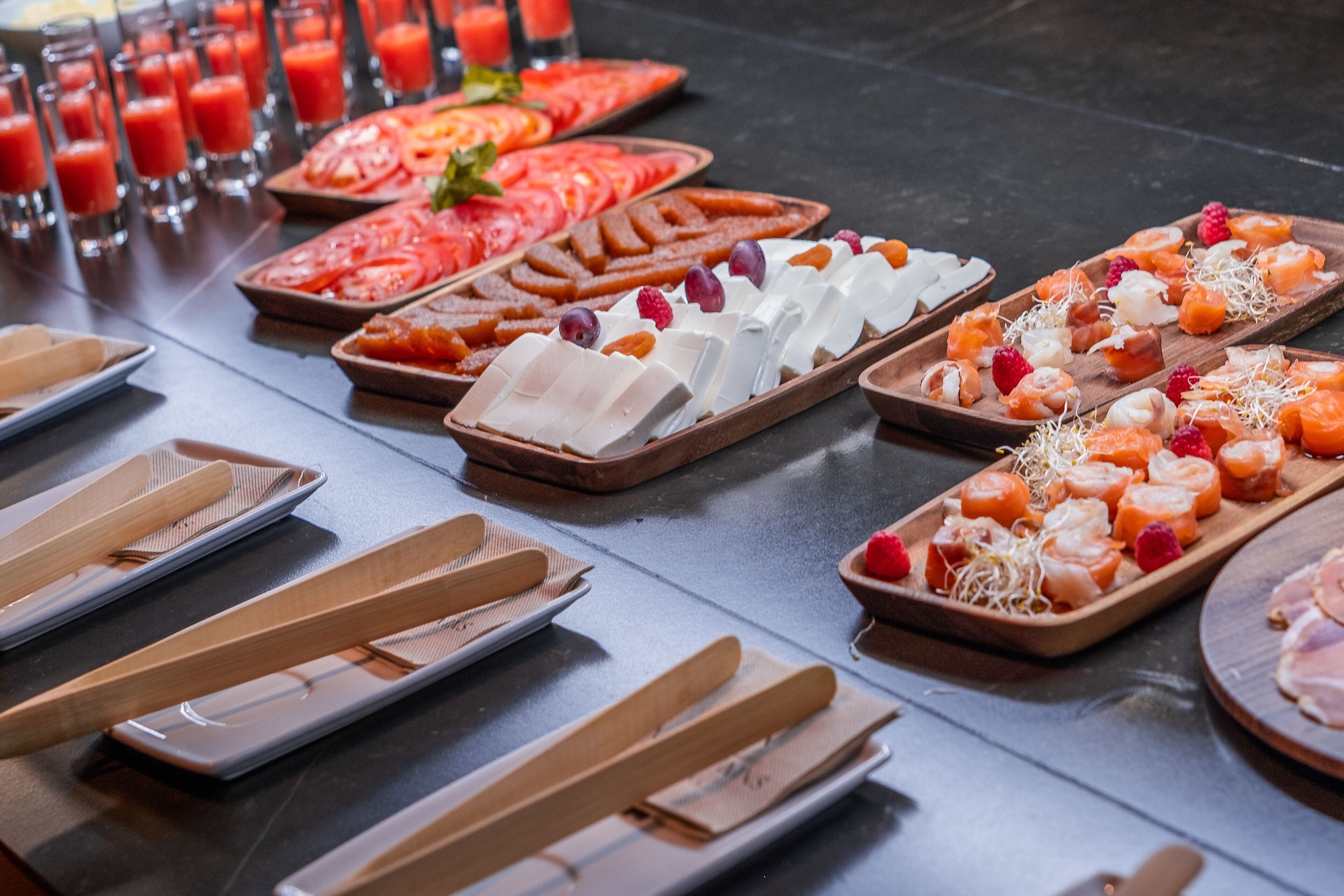 Un bufé con distintos alimentos y utensilios de madera.