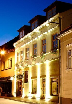 Ein Hotel mit einer klassischen Fassade, zahlreichen Fenstern und einem Schild, das es als Hotel kennzeichnet.