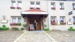 Een gebouw met een bord waarop 'Gasthaus-Engemann' staat en een houten ingang.