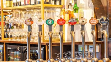 A bar with multiple beer taps and a variety of bottles in the background.