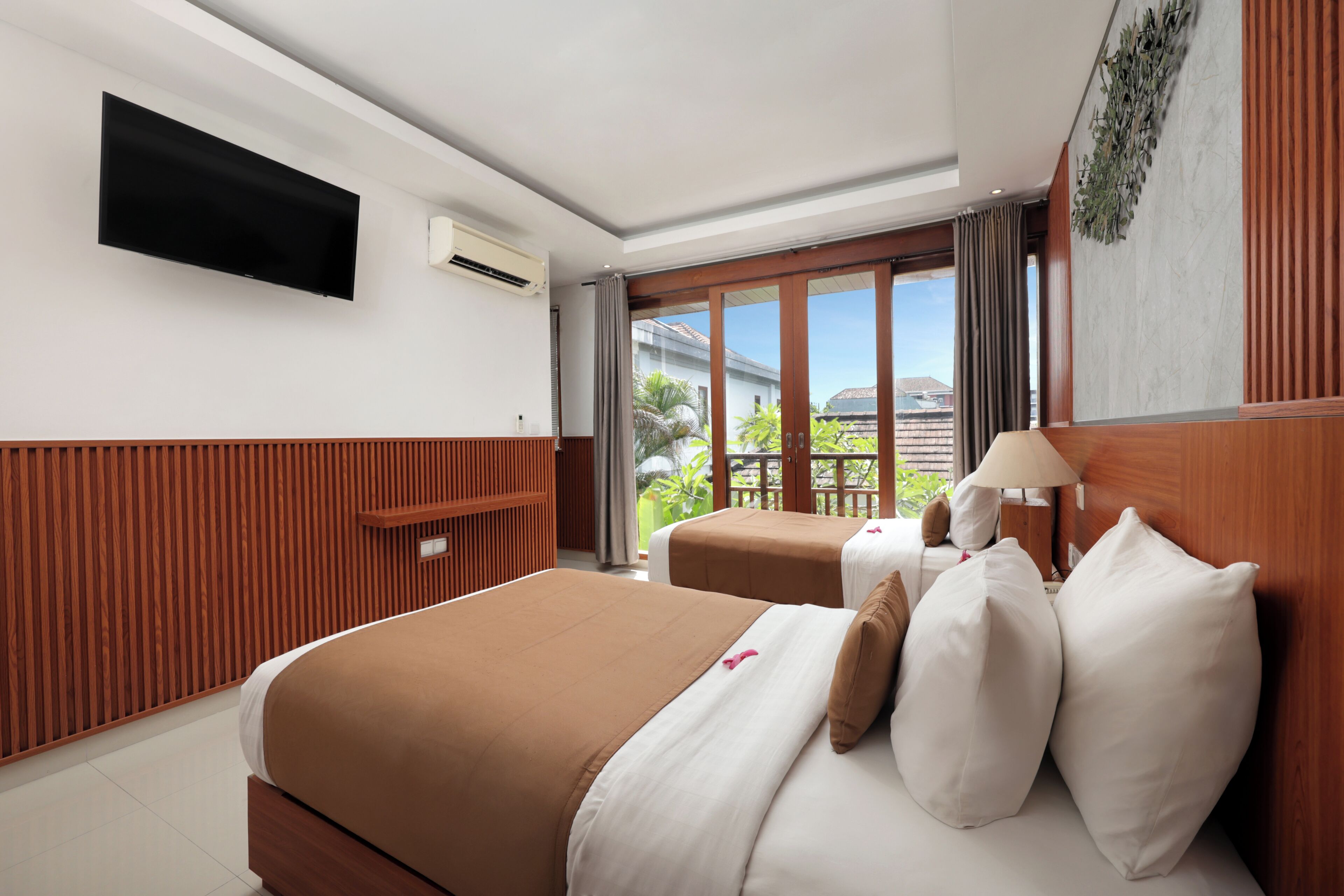 Une chambre d’hôtel avec un lit, une télévision, une fenêtre donnant sur l’extérieur et un panneau mural en bois.