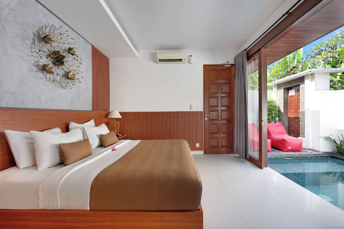 A modern bedroom with a large bed, a view of a swimming pool, and a sliding glass door leading to an outdoor area.