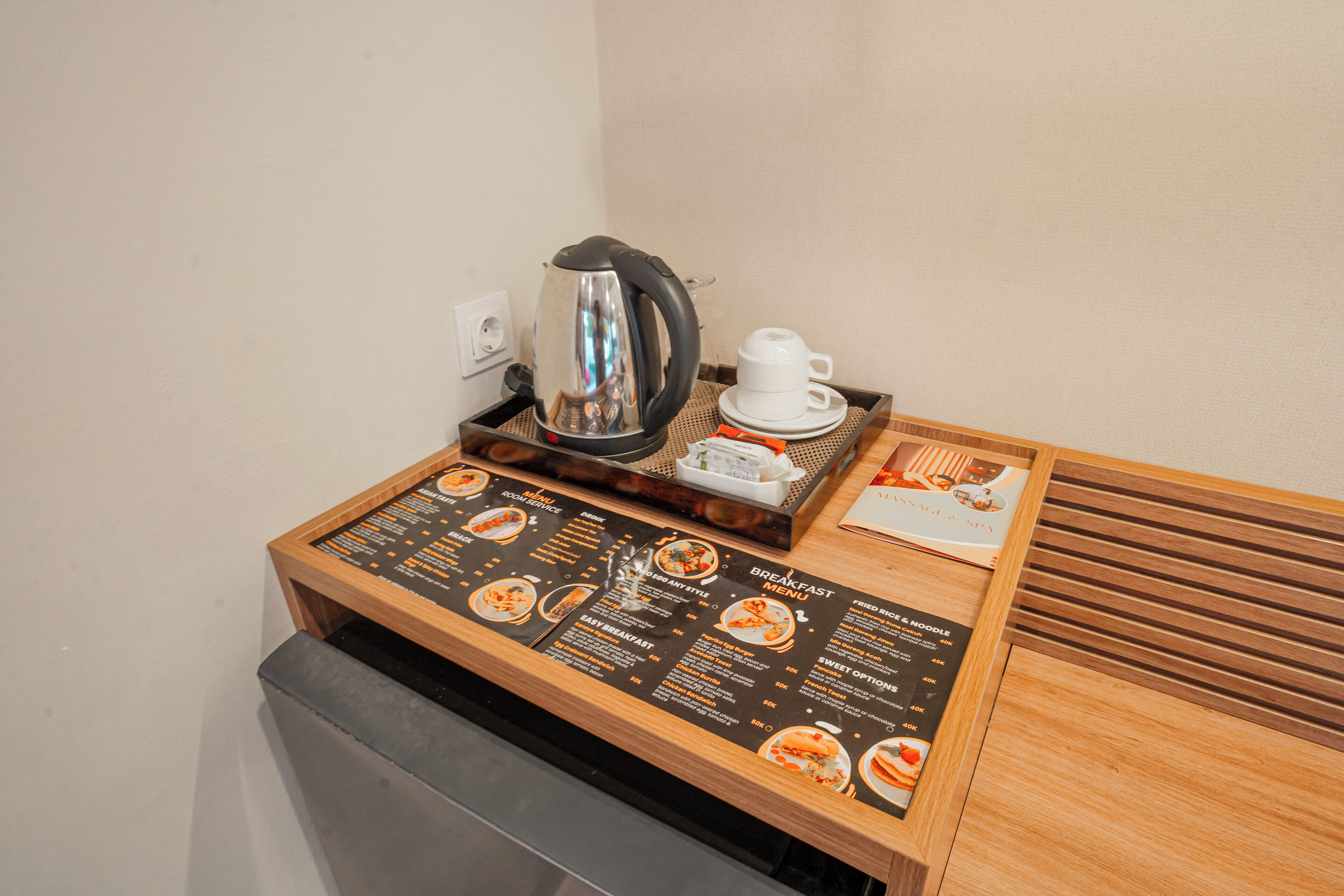 A breakfast station with a menu, a kettle, and a cup.
