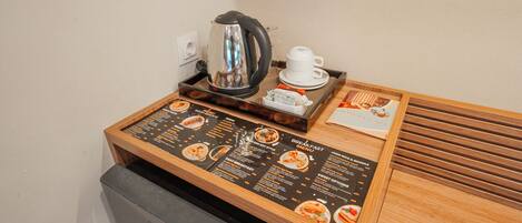 A breakfast station with a menu, a kettle, and a cup.