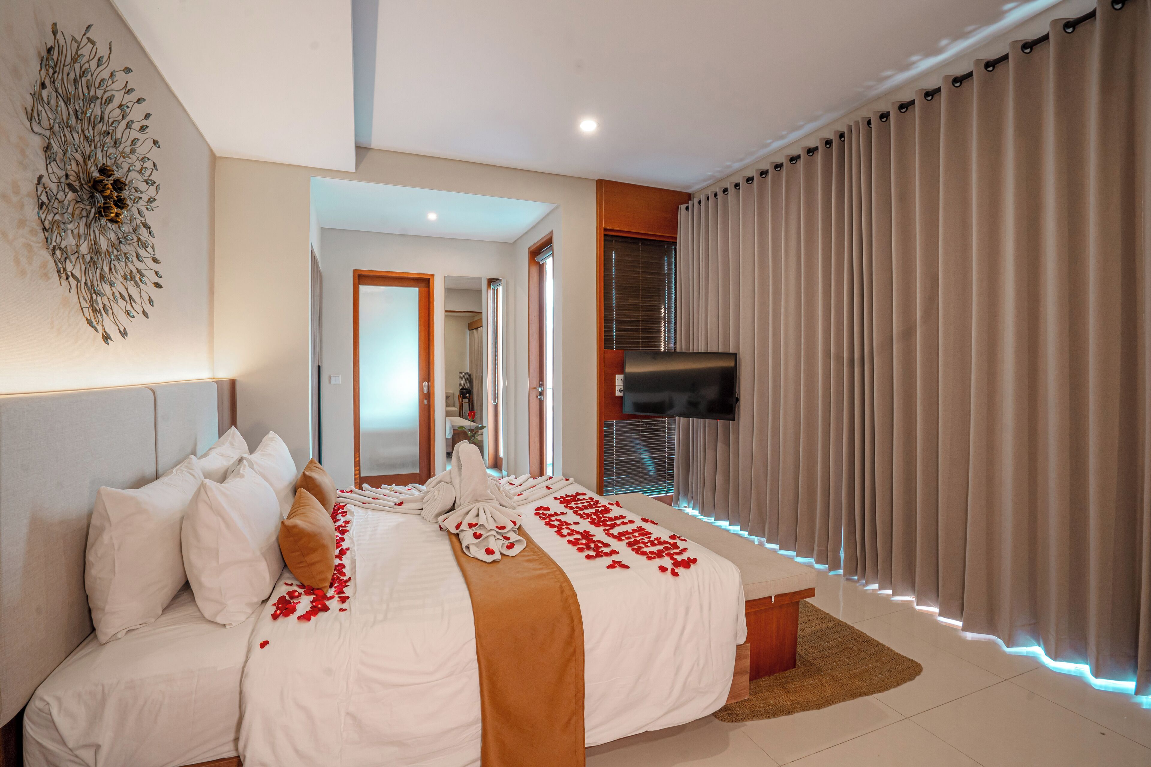 Een hotelkamer met een groot bed, een flatscreen televisie en uitzicht op het omliggende landschap.