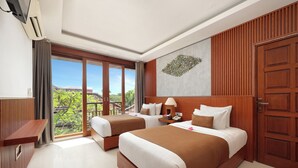 Een hotelkamer met twee bedden, een houten garderobe, een bureau, een groot raam met uitzicht en een wandairconditioner.