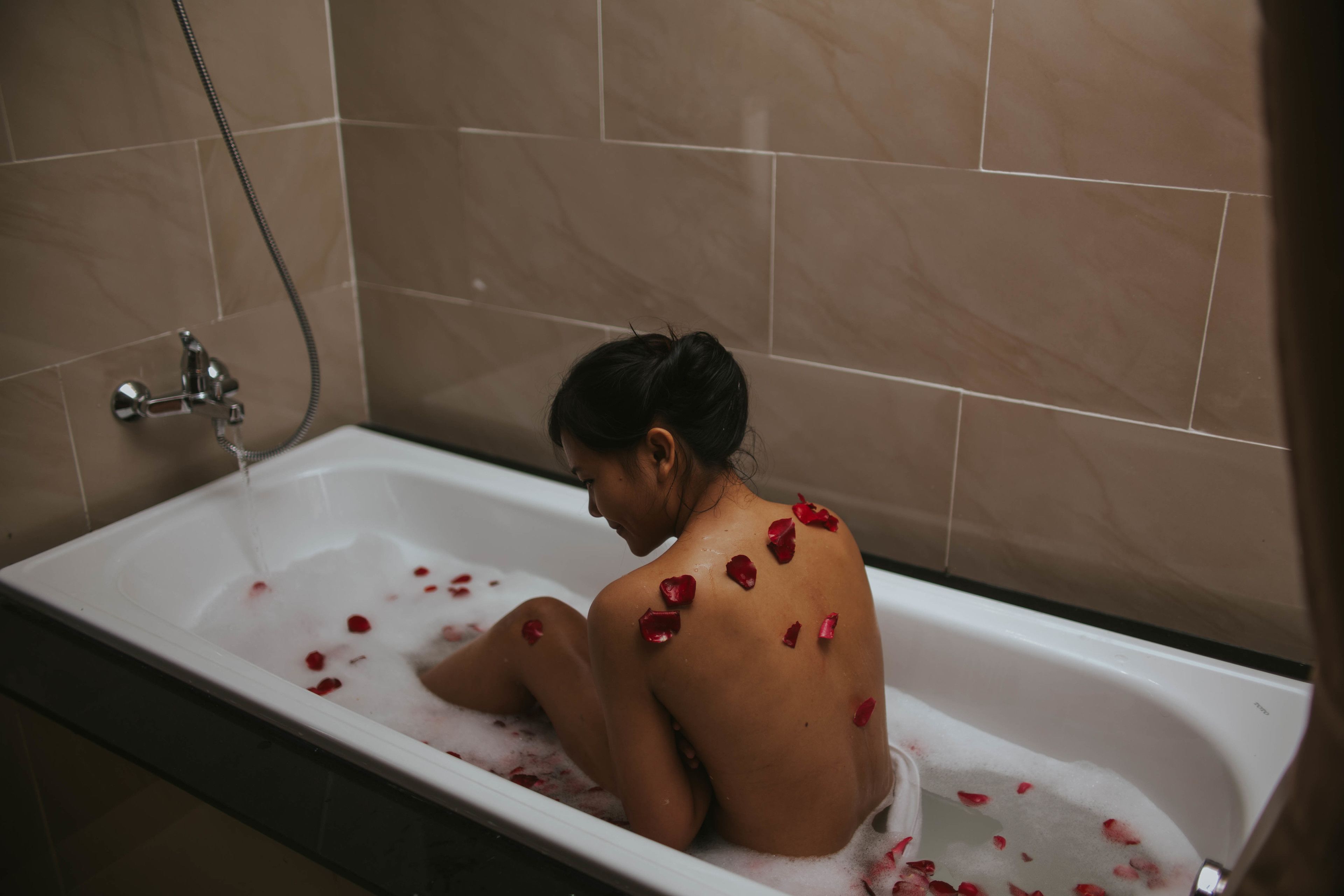 Una vasca da bagno con petali di rosa.
