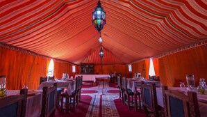A tented dining area with tables and chairs, a central chandelier, and a patterned carpet. - Camp Under Stars - Adults Only (Taouz)