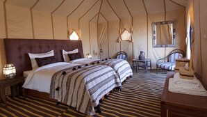 A tented room with two beds, a small table, a chair, and a mirror. - Camp Under Stars - Adults Only (Taouz)