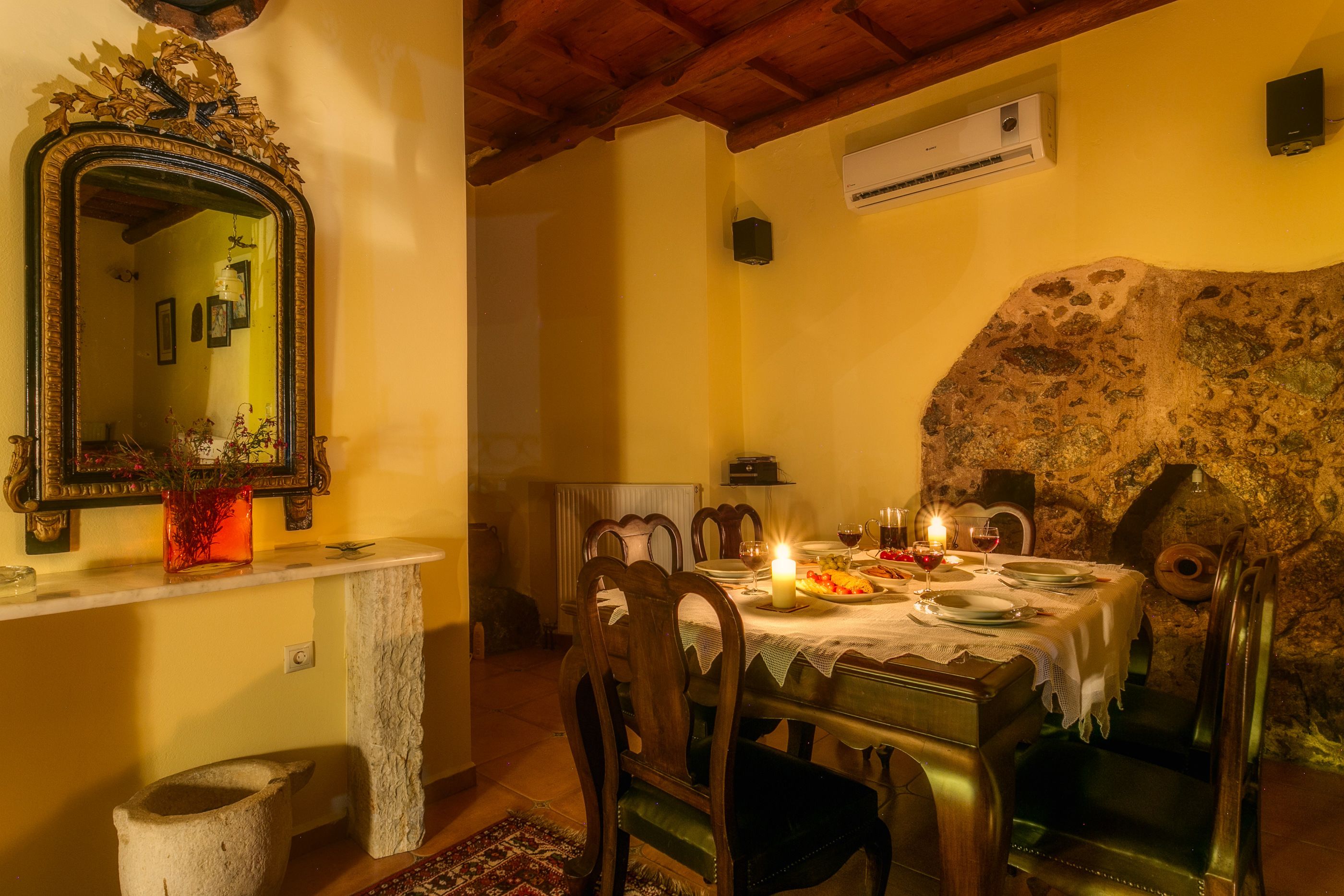 A dining area with a stone wall, a mirror, and a table set for a meal.