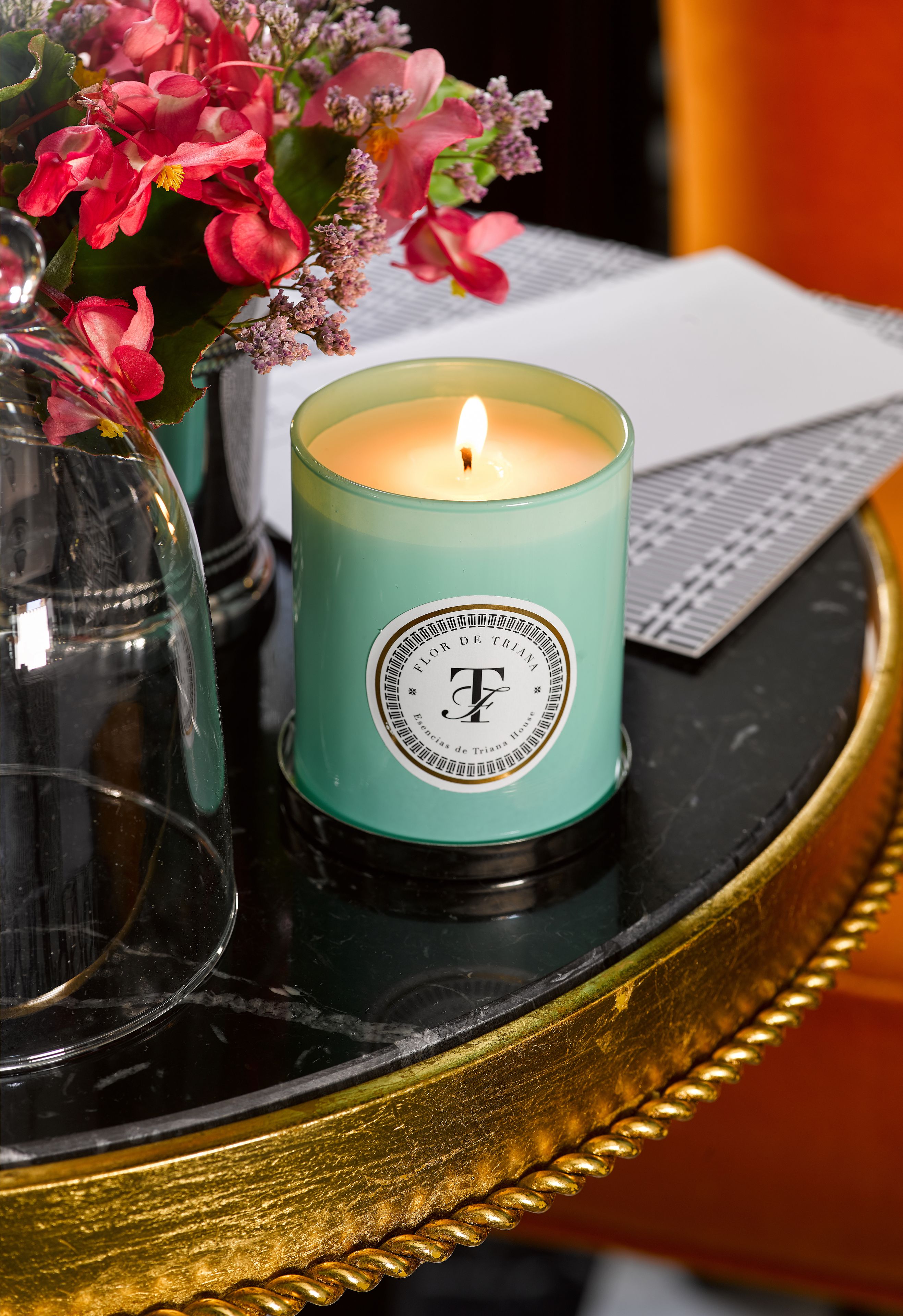 A teal candle with a label on a black table.