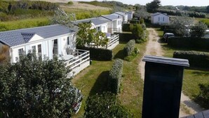 Une rangée de maisons mobiles avec une cour gazonnée et un chemin pavé.