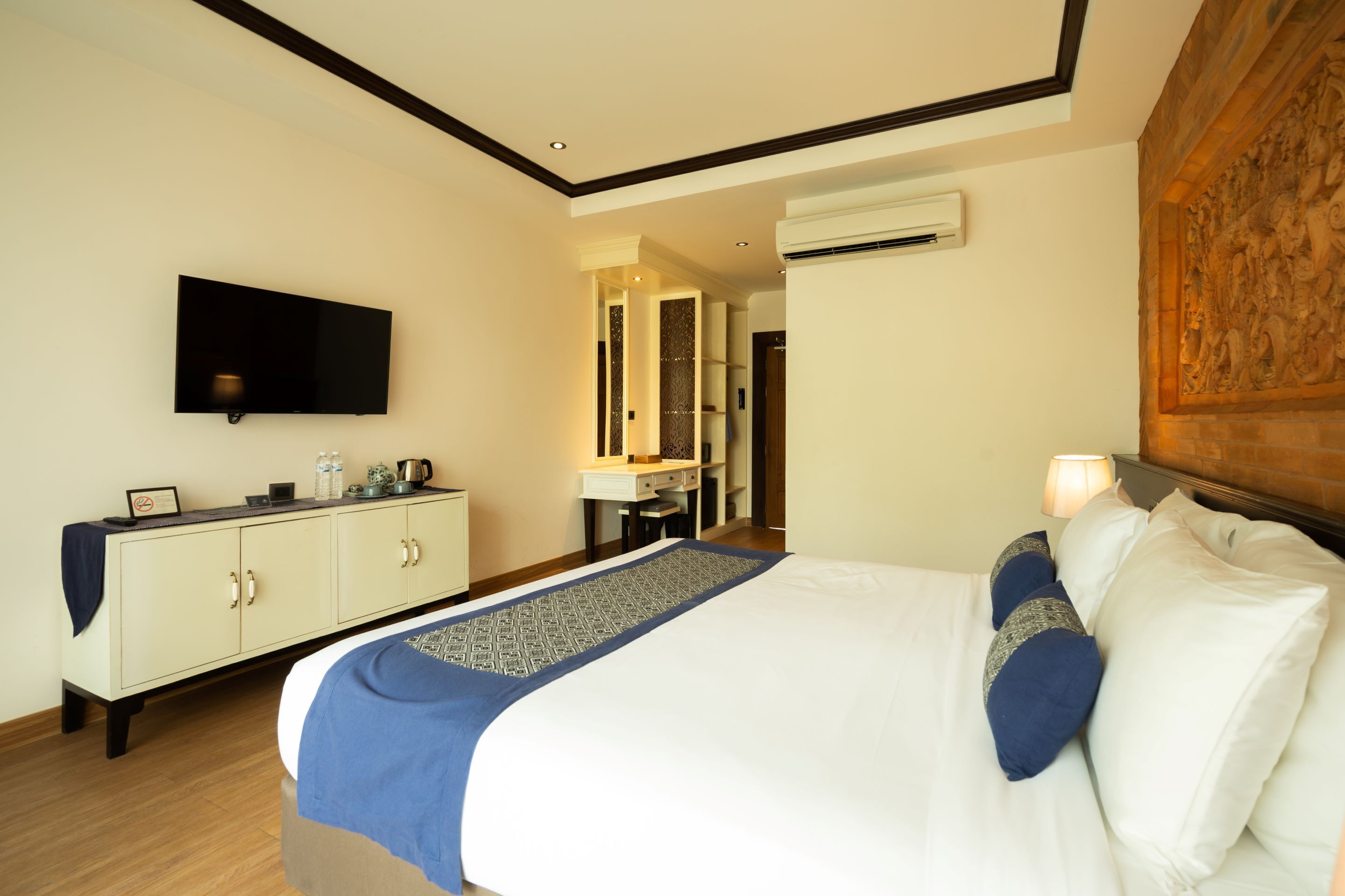 A hotel room with a bed, a TV, a desk, and a mirror.