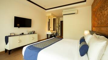 A hotel room with a bed, a TV, a desk, and a mirror.