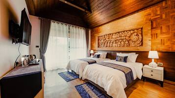 A hotel room with two beds, a TV, a bedside table, and a large decorative wall piece.