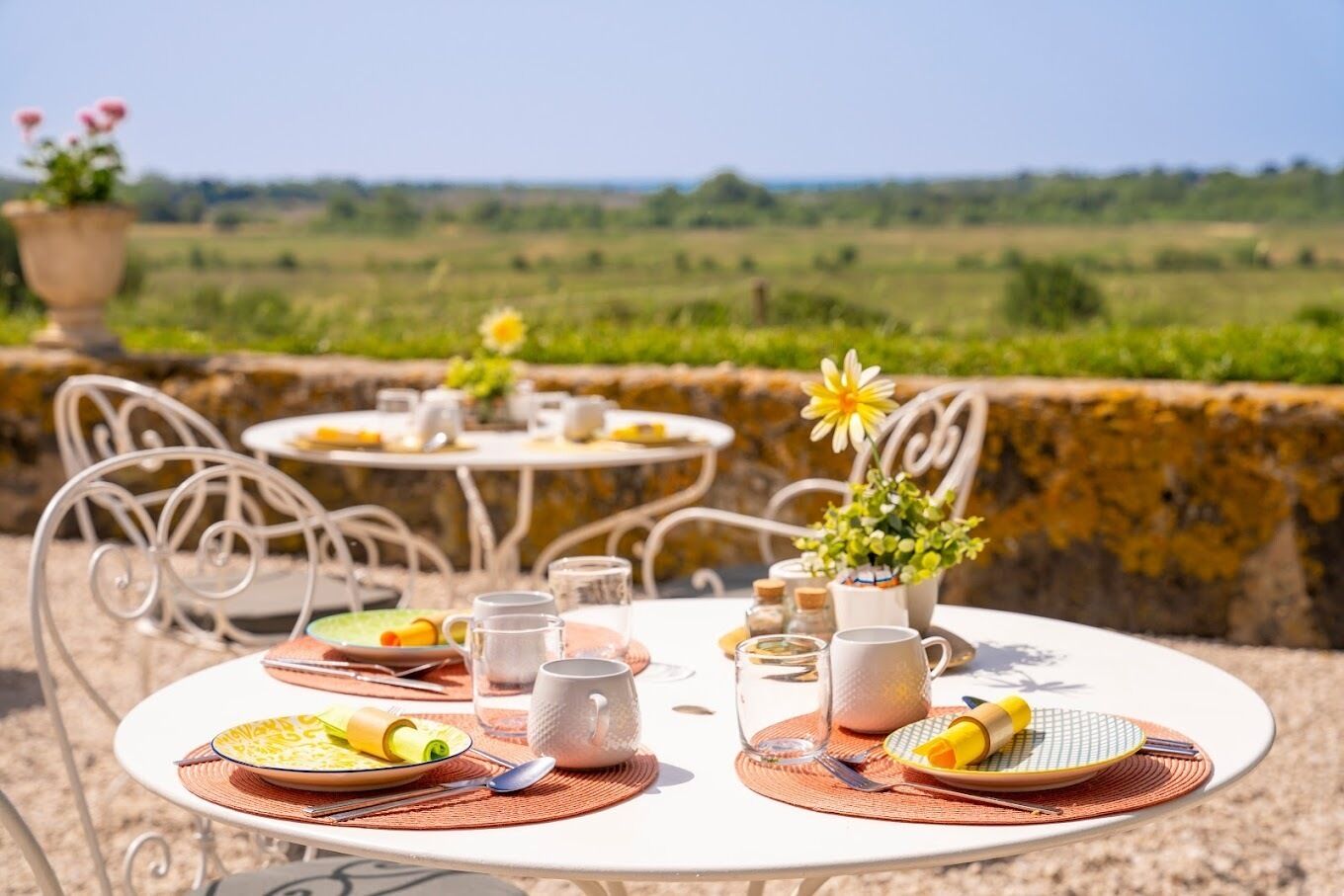 A table set outdoors with a view of a green landscape.