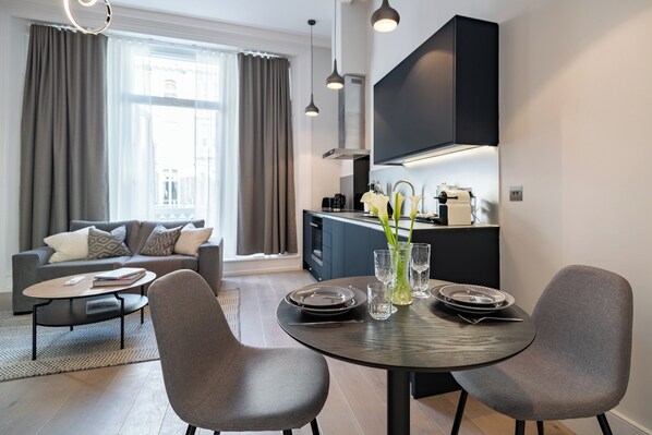 Un salon moderne avec un canapé, une table basse et une table à manger pour quatre personnes.