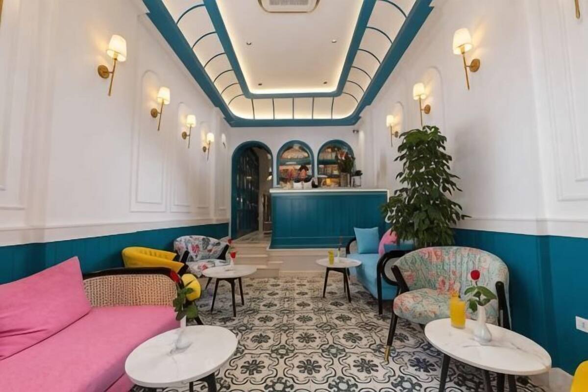 A hotel lobby with a central bar, seating areas, and a patterned floor.
