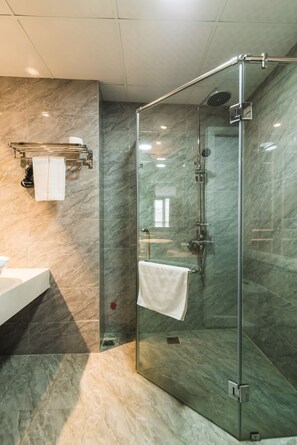 Habitación Deluxe | Baño | Regadera, regadera tipo lluvia, secadora de cabello, pantuflas 
