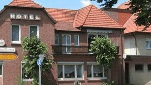 A brick building with a sign that reads "HOTEL" and a sign indicating "HOTEL RESTAURANT" below it. - Röhrs Gasthof (Sottrum)