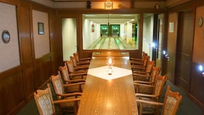 A bowling alley with a long wooden table and chairs in the center, surrounded by wooden walls and doors. - Röhrs Gasthof (Sottrum)