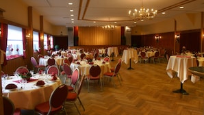 A banquet hall with multiple round tables, each set with red chairs and white tablecloths. - Röhrs Gasthof (Sottrum)