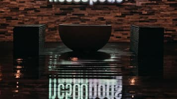 A sign with "nc500pods" and a large bowl in front of a brick wall.