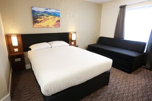 A hotel room with a large bed, a sofa, and a painting on the wall. - Talardy, St Asaph by Marston’s Inns (Saint Asaph)